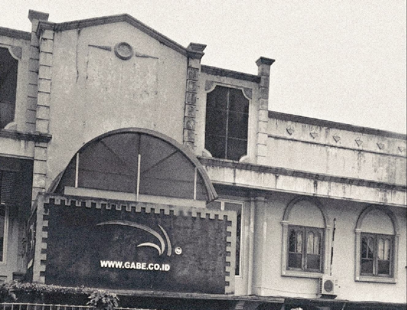Heritage colonial-era building with arched canopy and GABE signage