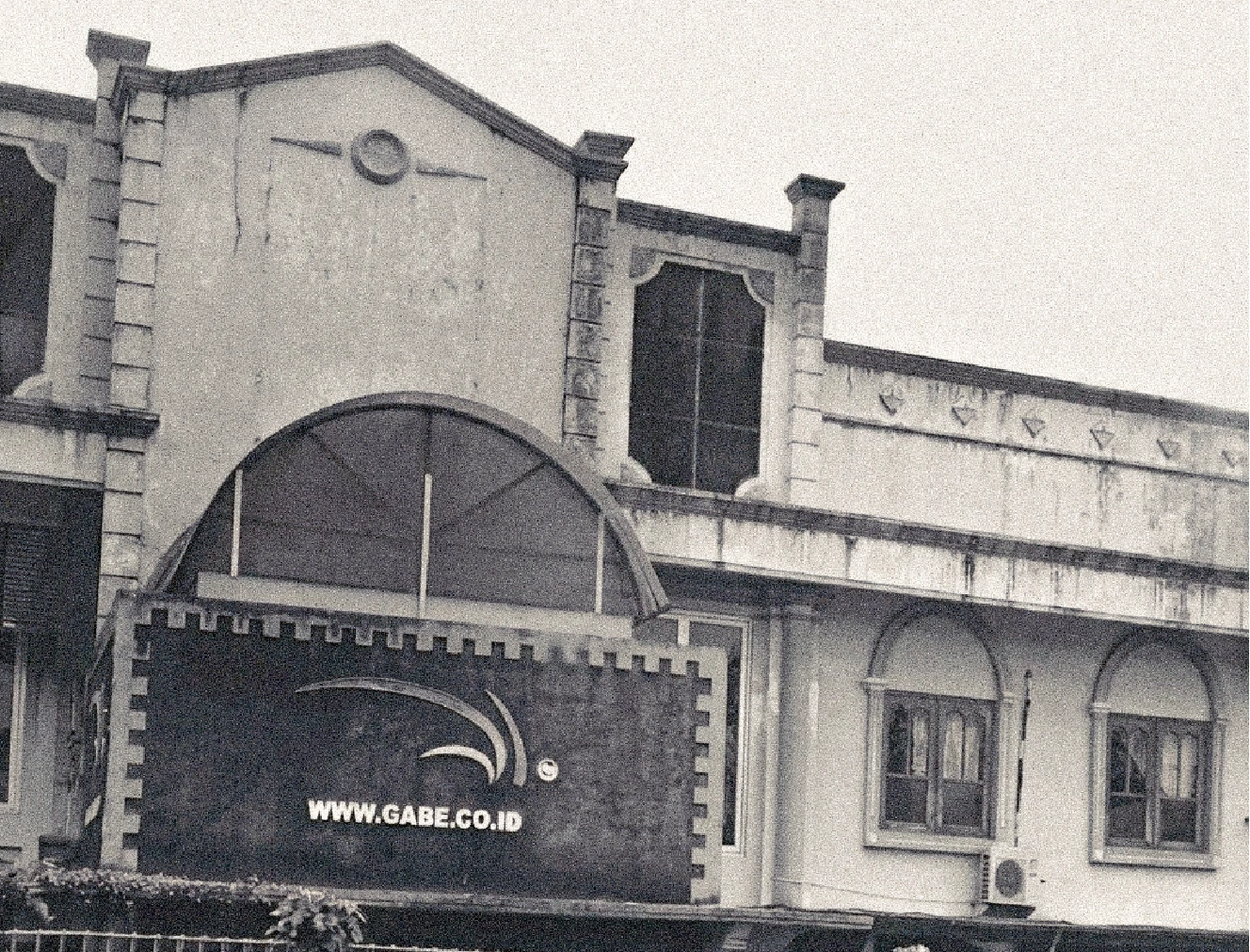 Heritage colonial-era building with arched canopy and GABE signage